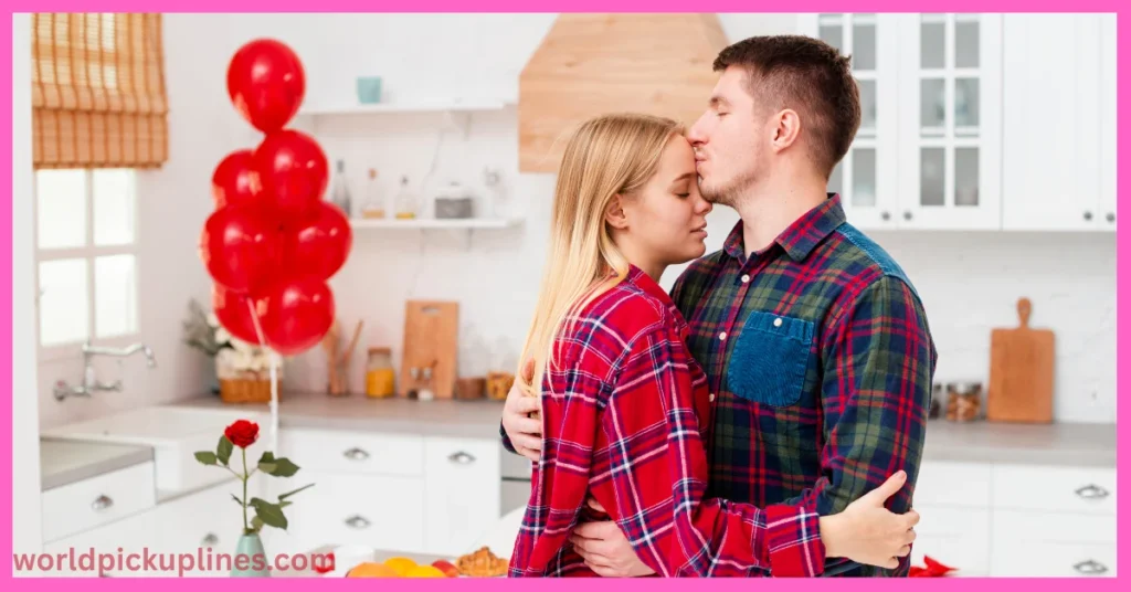 A man gently kissing a woman on the forehead while hugging in a bright kitchen decorated with red balloons and a single red rose.