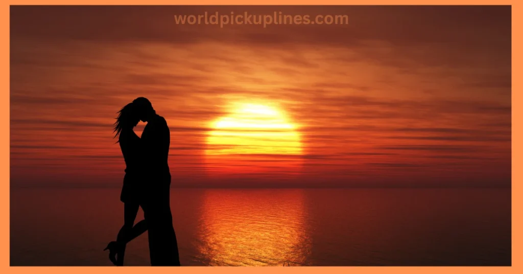 A silhouette of an embracing couple standing by the water against a vibrant, glowing orange sunset.