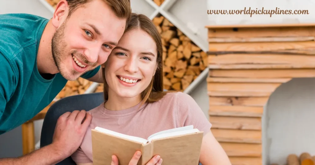 A smiling young couple leaning close together while holding an open book indoors.